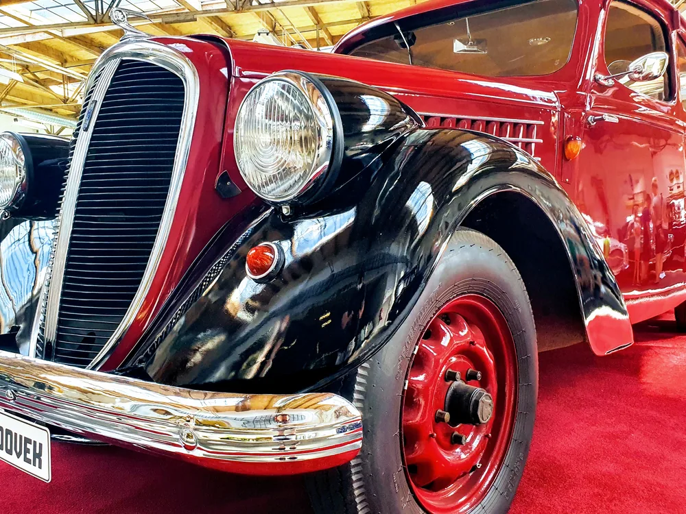 Historický automobil s úzkými dobovými pneumatikami v muzeu